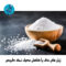 Salt in wooden scoop on dark stone table.